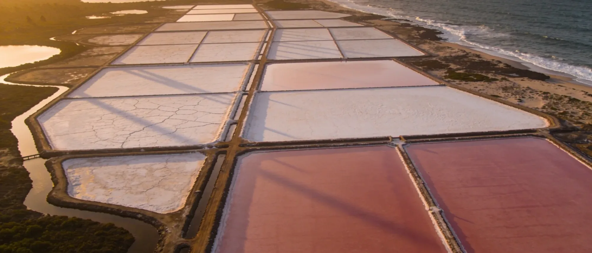 Aerial view of coastal salt evaporation pans on Ghana's Atlantic coast